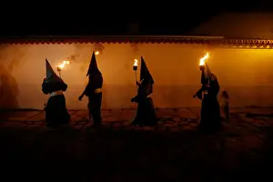 Penitents attend the Procession of the Torches during Holy Week in Goias Velho, west