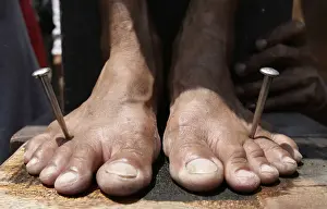 A penitents feet are nailed to a wooden cross on Good Friday in the town of San Juan in