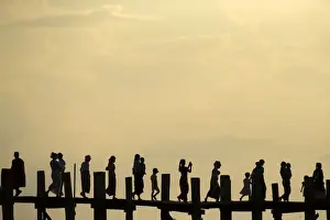 People cross U Bein bridge over Tuangthaman Lake in Mandalay, Myanmar