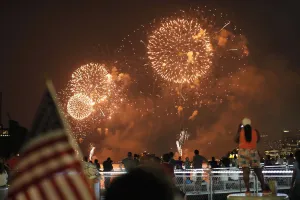 Prints of People look at fireworks exploding over the Hudson River and the skyline of New York during the Macys Independence Day celebration as seen from Hoboken, New Jersey, July 4, 2012 USA Prints: People look at fireworks exploding during Macys Independence Day celebration as seen