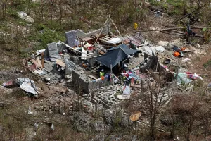 Storm Prints: People sit inside a destroyed house after Hurricane Matthew hit Jeremie