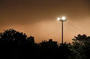 India Prints: People stand on the roof of a house during a dust storm in New Delhi