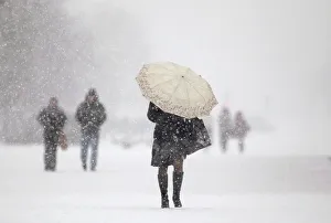 People walk during heavy snowfall in central Minsk