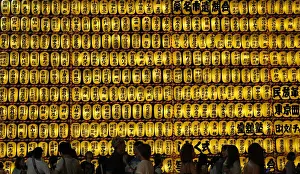 People walk in front of paper lanterns during the Mitama Festival at the Yasukuni