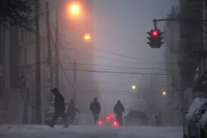 People walk across a snow covered street in Hoboken, New Jersey People walk across a snow covered street in Hoboken, New Jersey