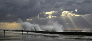 Cuba Prints: People walk as waves crash on the El Malecon seafront boulevard