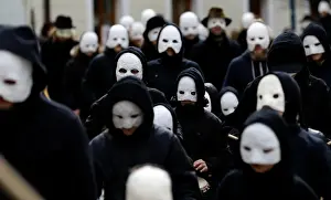 People wearing masks march through the streets during Easter celebrations in Ceske