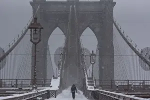 A person walks over the Brooklyn Bridge during winter storm Niko in New York City