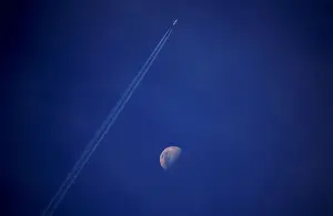 Prints of A plane leaves a vapor trail as it flies past the moon above the town of Gunnedah, New South Wales, Australia July 21, 2018. Picture taken July 21, 2018. REUTERS/David Gray TPX IMAGES OF THE DAY Australia Prints: A plane leaves a vapor trail as it flies past the moon above the town of Gunnedah