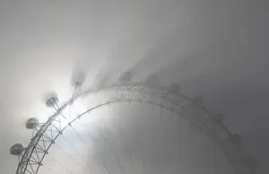 United Kingdom Prints: The pods on the London Eye casts shadows against a thick morning fog as the spring