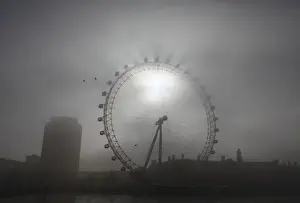 The pods on the London Eye casts shadows against a thick morning fog as the spring