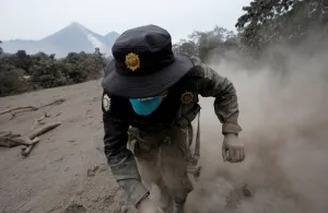 Guatemala Prints: A police officer stumbles while running away after the Fuego volcano spew new pyroclastic