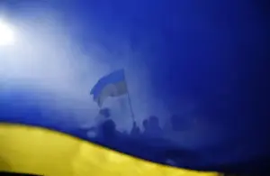 Pro-Ukrainian supporters are seen though a Ukrainian flag as they take part in a rally