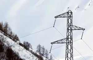 France Prints: Pylon of high-tension electricity power lines is pictured on snow-covered mountain in