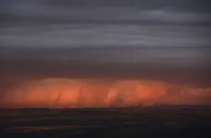 Rain clouds are lit by the setting sun, looking south from Hadrians Wall near Hexham in