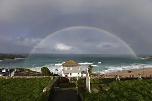 United Kingdom Prints: A rainbow forms as a squall moves towards Porthmeor Beach in St Ives in Cornwall
