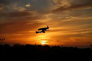 A remote-controlled plane in the form of a witch flies over a neighborhood as