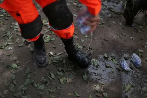 Guatemala Prints: A rescue worker cools off his boots with water near an area affected by the eruption of