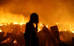 Kenya Prints: A resident reacts as he attempts to extinguish a fire that broke out at the Kijiji slums