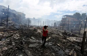 Prints of A resident is seen after a fire at Educandos neighbourhood, on a branch of the Rio Negro, a tributary to the Amazon river, in the city of Manaus, Brazil December 18, 2018 Brazil Prints: Resident is seen after a fire at Educandos neighbourhood, on a branch of the Rio Negro
