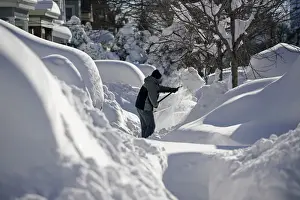 Weather Prints: A resident shovels snow away from the entrance to his home in Union City