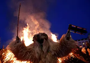 Hungary Prints: A reveller wearing a mask dances near a bonfire during the traditional Buso Carnival in