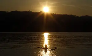 A rower is seen during sunset on Lake Zurich on a mild and sunny spring day near Kuesnacht