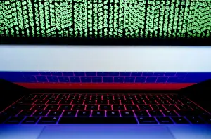 Cyber Prints: Russian flag is seen on the laptop screen in front of a computer screen on which cyber