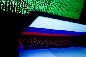 Cyber Prints: Russian flag is seen on the laptop screen in front of a computer screen on which cyber