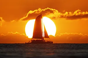 A sail boat passes in front of the sun as the last rays of sunlight of 2011 hit