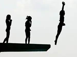 Schoolgirls dive from a five-metre platform at a swimming pool in Oiso