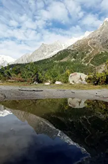 A segment of the Planpincieux glacier is reflected in water on the Italian side of
