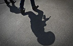The shadow of a gunfighter is cast on the asphalt as competitors practice prior to The shadow of a gunfighter is cast on the asphalt as competitors practice prior to