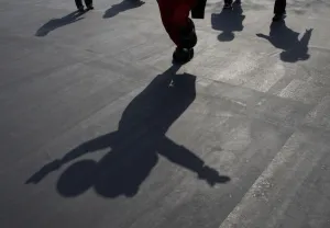 Japan Prints: A shadow of Mickey Mouse is cast as the Disney character waves to visitors at Tokyo