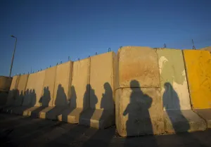 Palestinian Prints: Shadows of Palestinian women are seen at Qalandiya checkpoint outside Ramallah