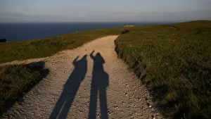 The shadows of Reuters photographer Phil Noble and journalist Mari Saito are seen during
