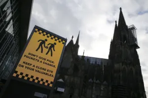 Prints of An electronic information sign warning the general public against pickpockets, is displayed on an advertising board outside the main railway station and in front of Cologne Cathedral in Cologne Germany Prints: Sign warning against pickpockets is displayed outside main railway station