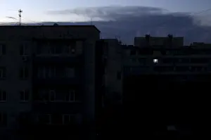 Single light illuminates a room during a blackout at a residential building in