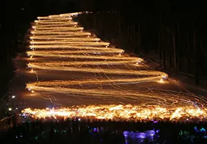 Prints of Hundreds of skiers and snowboarders hold lit torches and flashlights while descending from a slope during an annual festival in the Siberian town of Zheleznogorsk near Krasnoyarsk, Russia March 3 Russia Prints: Skiers and snowboarders descend from a slope during an annual festival in Zheleznogorsk