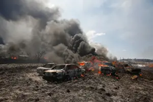 Honduras Prints: Smoke billows from burning cars during a fire at a plot where police kept seized vehicles