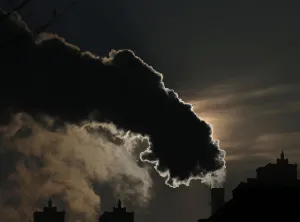 Prints of Smoke from a chimney is silhouetted against the rising sun in the northern city of Harbin, Heilongjiang province, January 6, 2014 China Prints: Smoke from a chimney is silhouetted against the rising sun in the northern city of Harbin