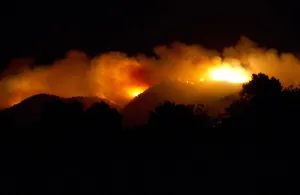 Spain Prints: Smoke rises from a burning forest near the village of Sant Joan de Labritja on