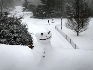 A snowman sits on a bridge in Central Park as snow falls in New York