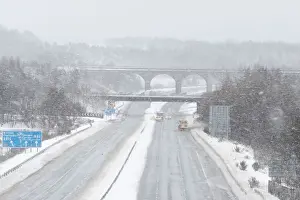 Weather Prints: Snowploughs work on the M80 motorway after it was closed to clear vehicles stranded by