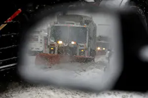Weather Prints: A snowplow is seen in a cars side mirror in upper Manhattan during Storm Grayson in New