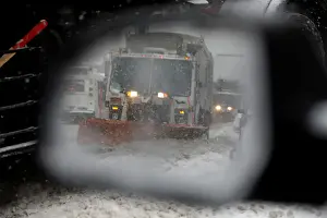 Images Dated 4th January 2018: A snowplow is seen in a cars side mirror in upper Manhattan during Storm Grayson in New