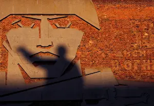 A statue of Soviet state founder Vladimir Lenin casts a shadow on a bas-relief in Volgograd