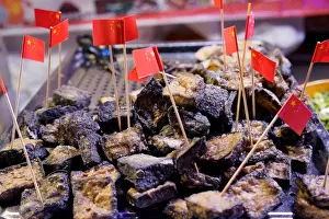 Stinky tofu with cocktail sticks are seen at a street market in the township of Guiyu
