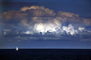 A storm cloud can be seen behind a yacht as it sails off the coast of Sydney