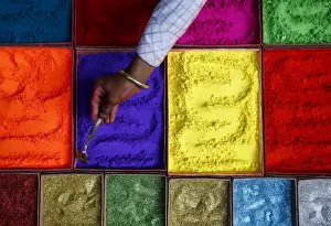 A street vendor spreads vermilion powder used for worship during the Tihar festival
